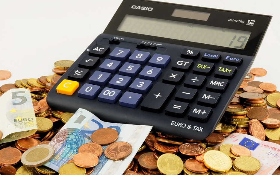 Black calculator on top of coins